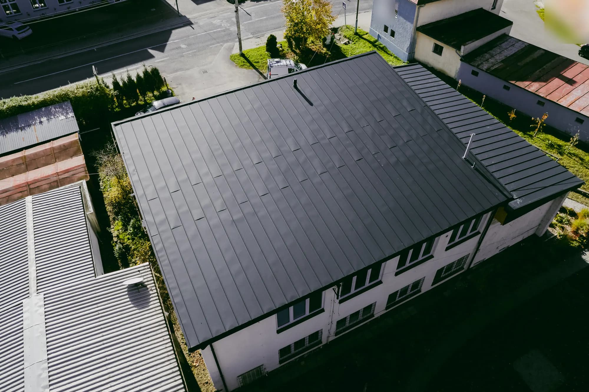 Dronový pohľad na dvojpodlažný dom služieb v Nižnej so strechou z tmavosivého click panelu