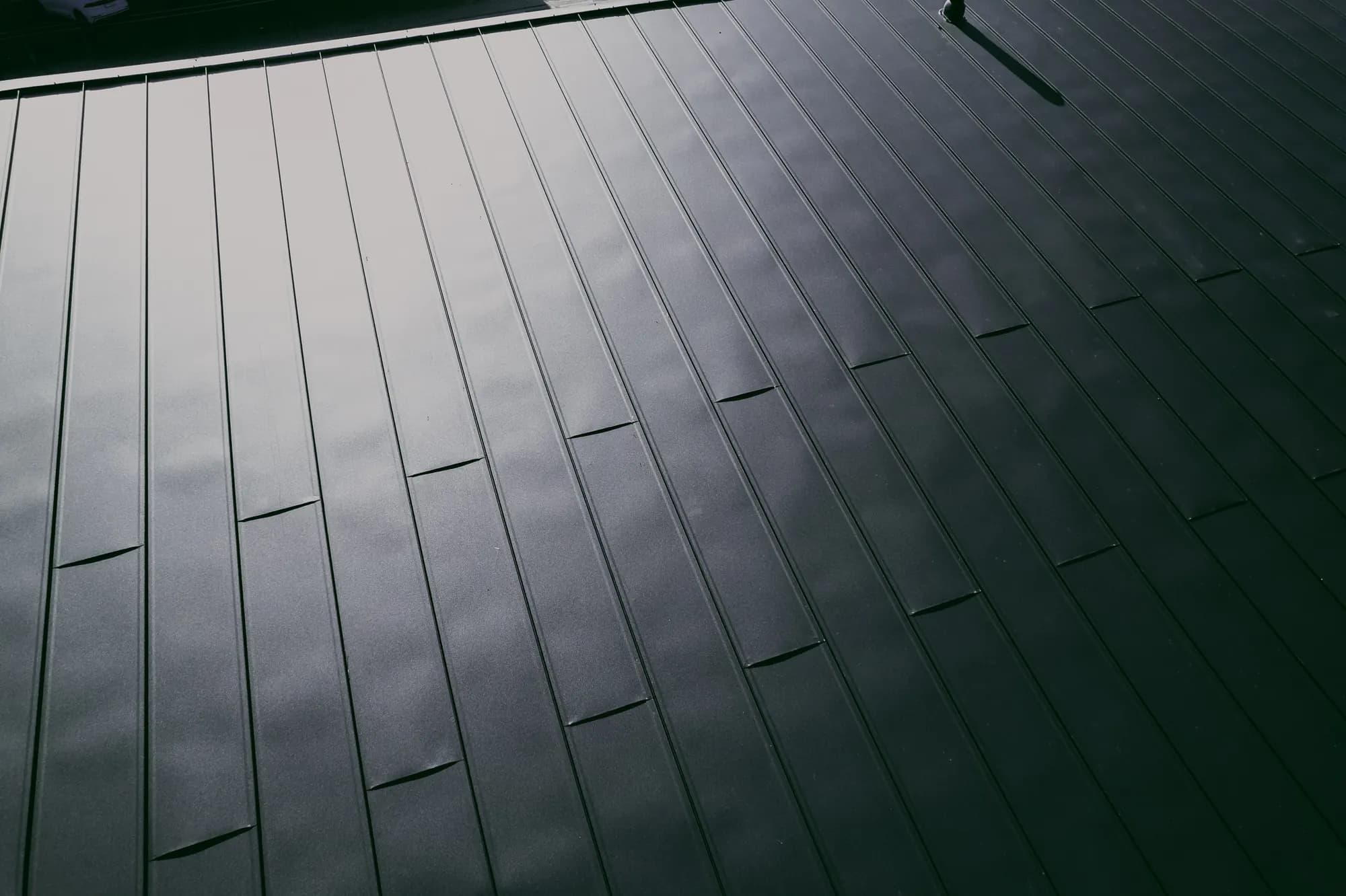 Detail pásov click panelu v tmavosivej farbe na streche domu služieb v Nižnej