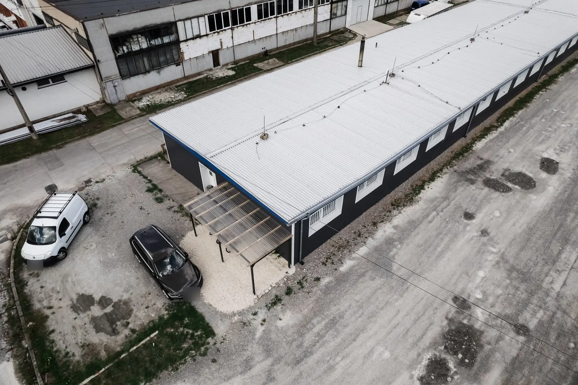 Dronový pohľad na dlhú výrobnú halu so strechou z trapézového plechu aluzinok v Nižnej