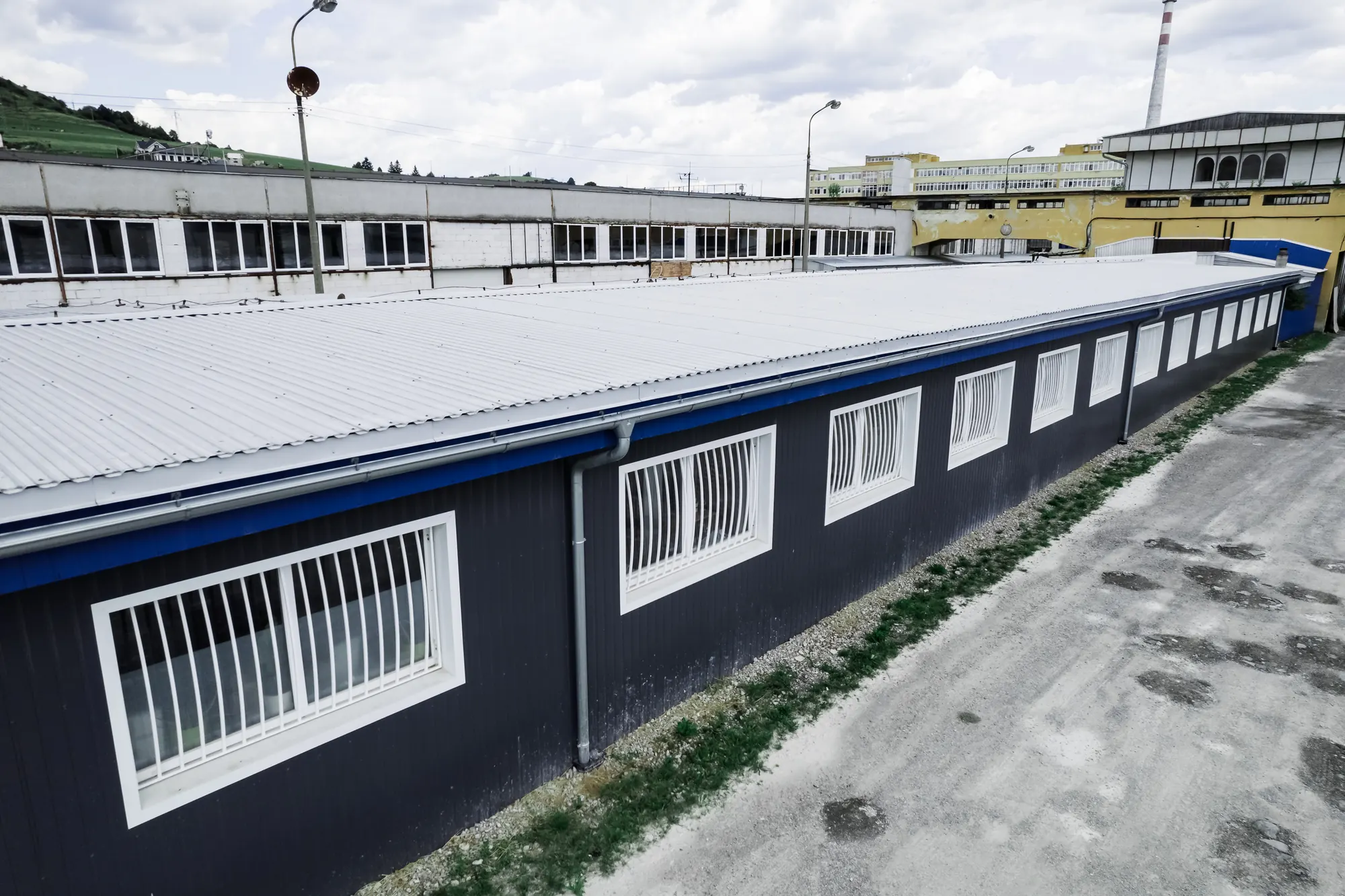 Strecha a odkvap výrobnej haly z trapézového plechu aluzinok pozdĺž fasády, Nižná