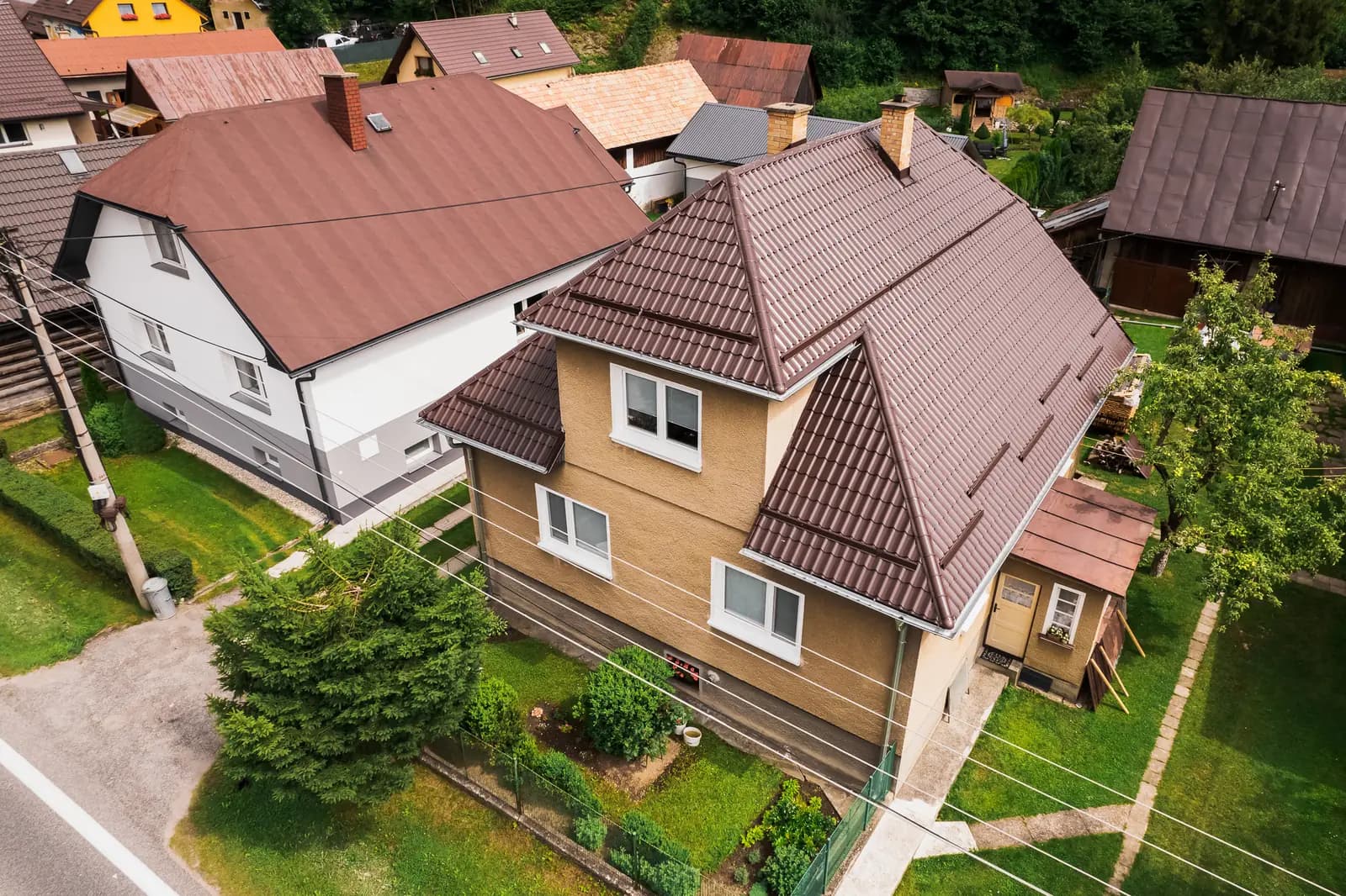 Dronový pohľad na rodinný dom so strechou zo škridloplechu v hnedej farbe v Krivej