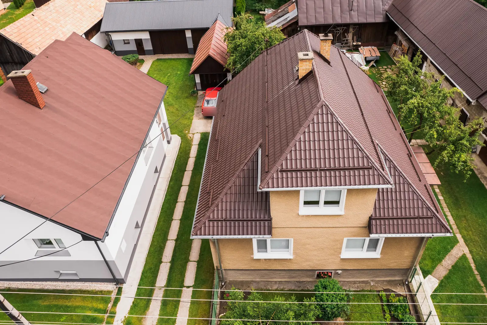 Čelný pohľad z dronu na štíty a strechu z hnedého škridloplechu, rodinný dom v Krivej