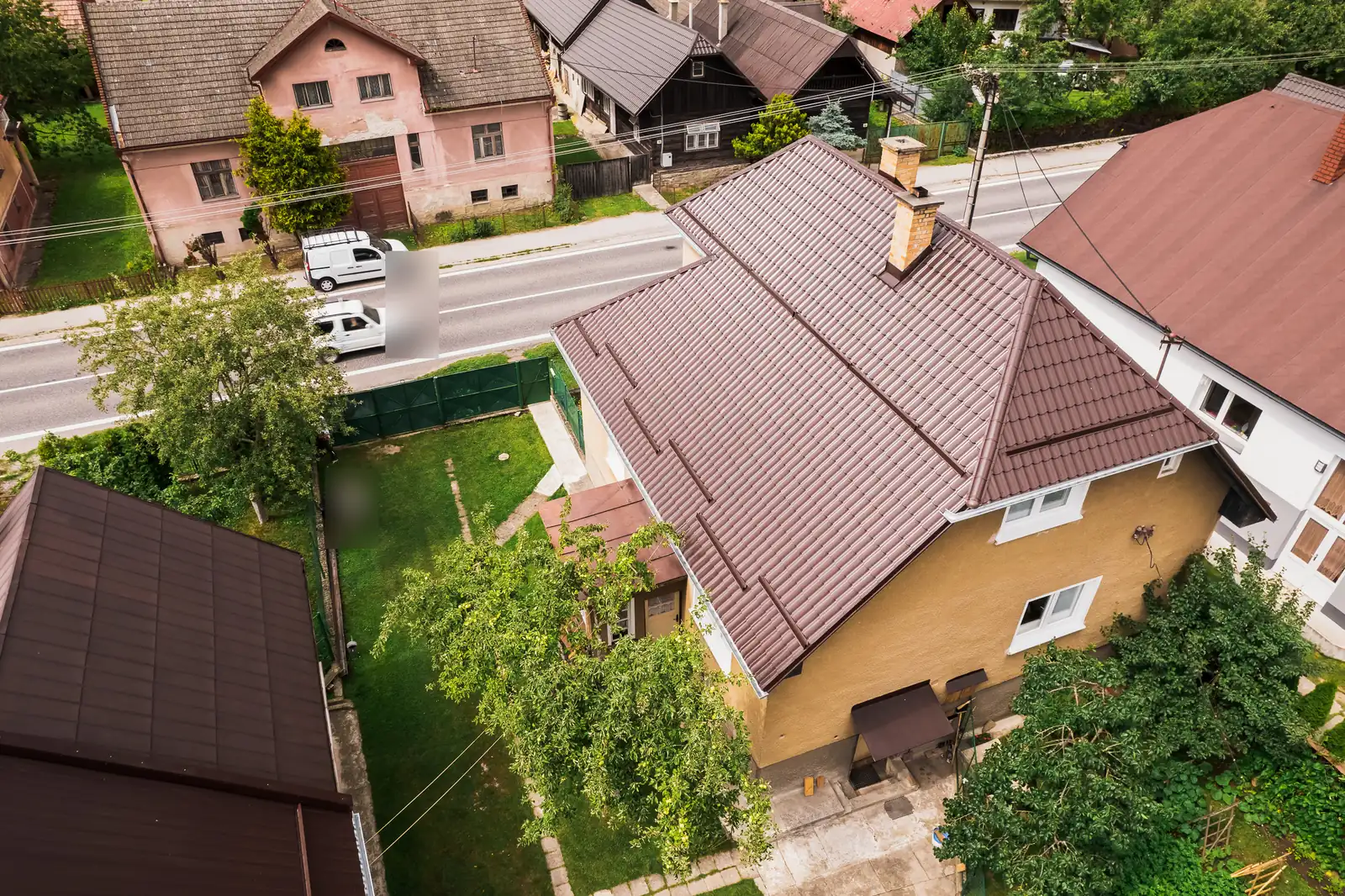 Strecha z hnedého škridloplechu na rodinnom dome v Krivej, šikmý pohľad z dronu od záhrady