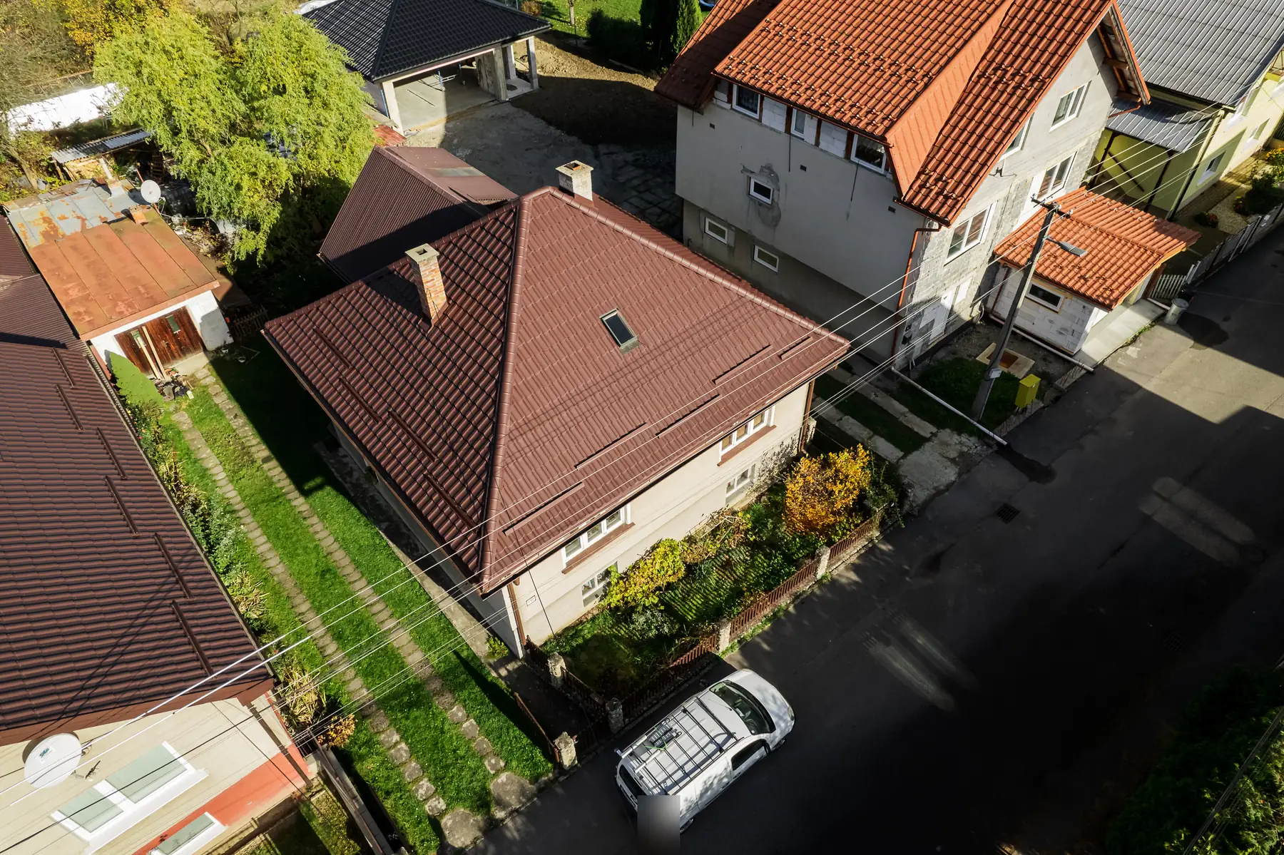 Dronový pohľad na rodinný dom s valbovou strechou z hnedého škridloplechu v Nižnej