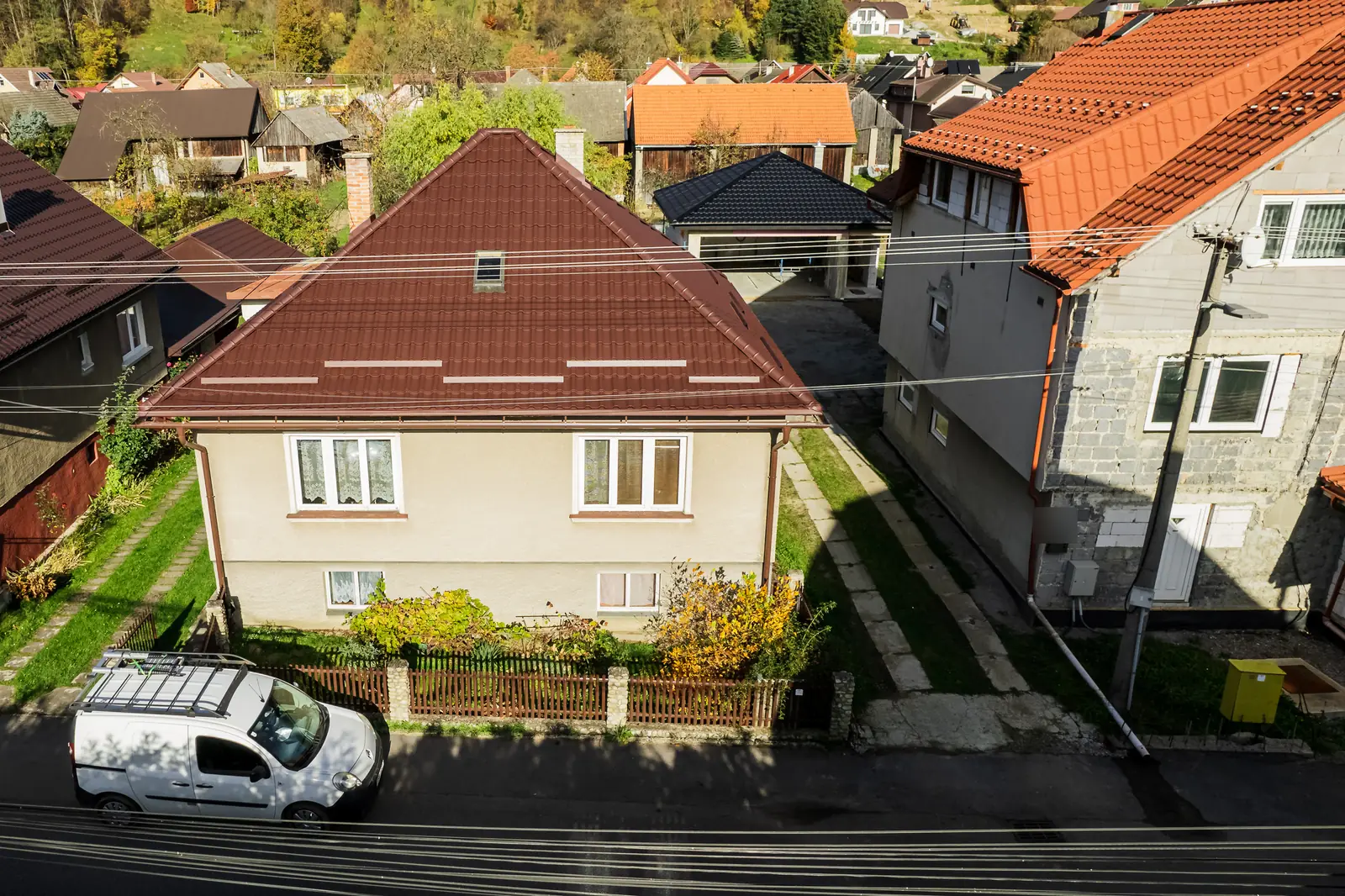 Rodinný dom v Nižnej so strechou z hnedého škridloplechu a sneholapačmi, pohľad z dronu